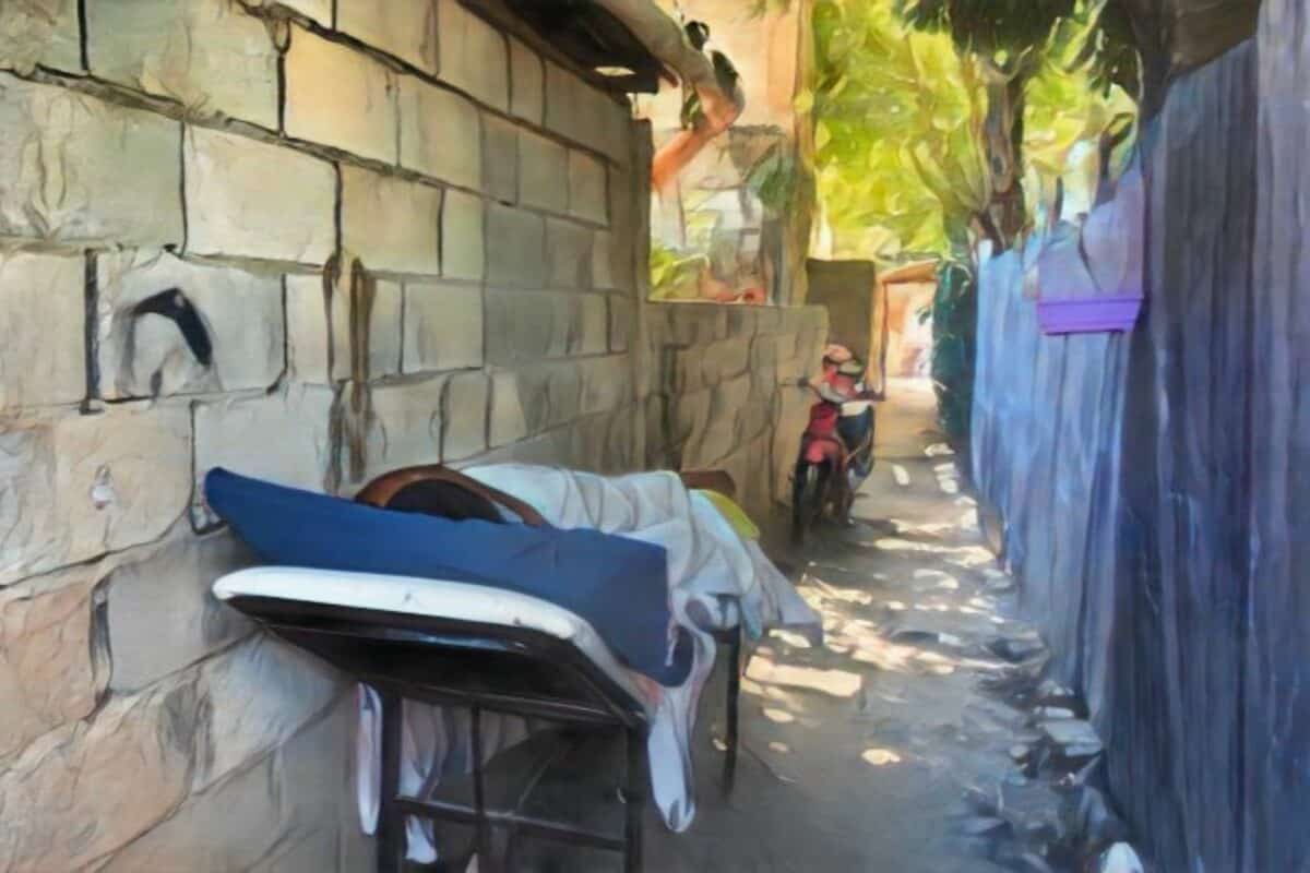 Sobreviviente de agresión en La Vega convalece en un callejón por el intenso calor dentro de su vivienda